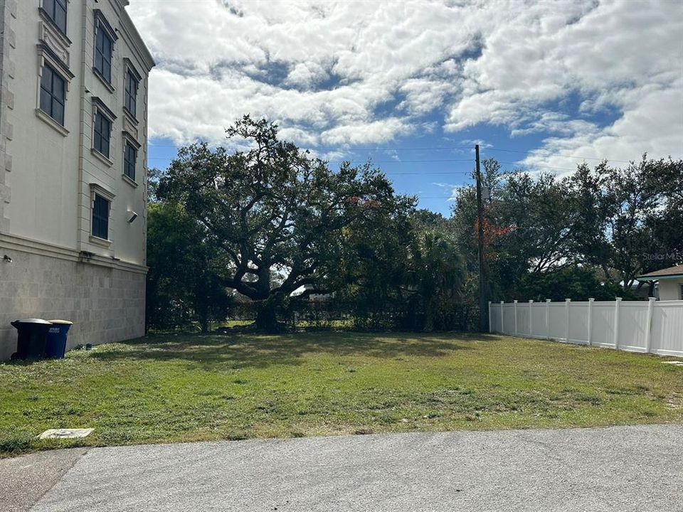 Your Dream is Land Lot is located in between of RaceCarMansion and the American Dream white fence with a lovely vacation home behind it.  Lot is backing into vast landscaping surrounding distant sand volleyball courts of Calvary Private HS.