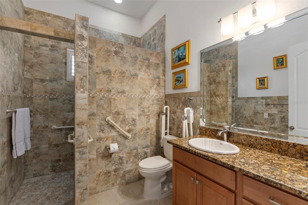 The full bath features a walk in closet, handicapped commode, solid wood cabinetry and granite counter-tops