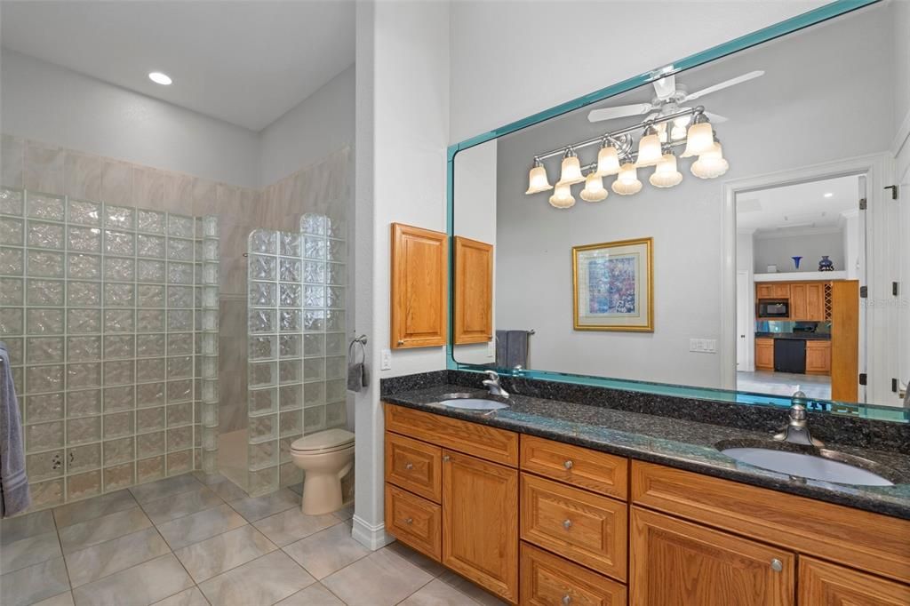 The caretaker ensuite includes a walk in shower, solid wood cabinetry, dual sinks, and granite counter tops