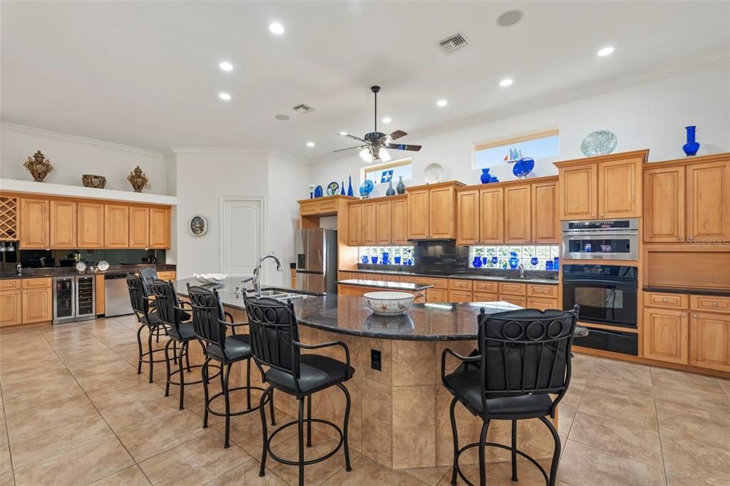 The chefs kitchen is well adorned with granite countertops, solid wood cabinetry, prep sink, full wet bar, wall oven, convection microwave and newer appliances