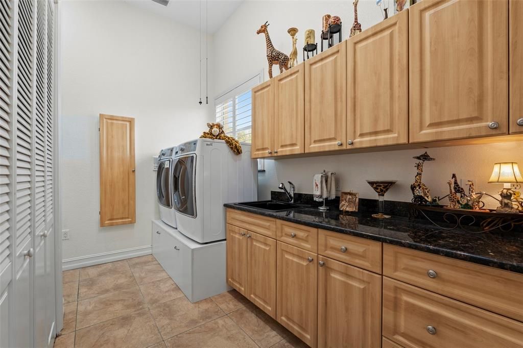 The laundry room is just off the kitchen and boasts granite countertops, solid wood cabinetry and back access from the master bedroom