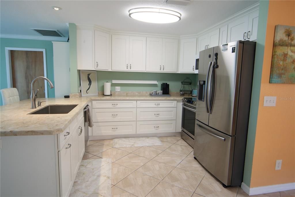 Open kitchen, breakfast bar and dining area all have quartz counter tops throughout.