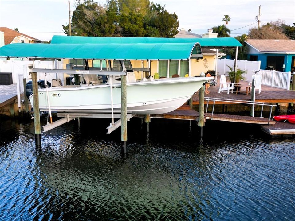 Covered reinforced remote controlled 10,000 LB plus boat lift with wrapped poles.