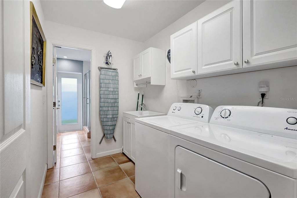 Extra large laundry room adjacent to the well-appointed pool bath behind.