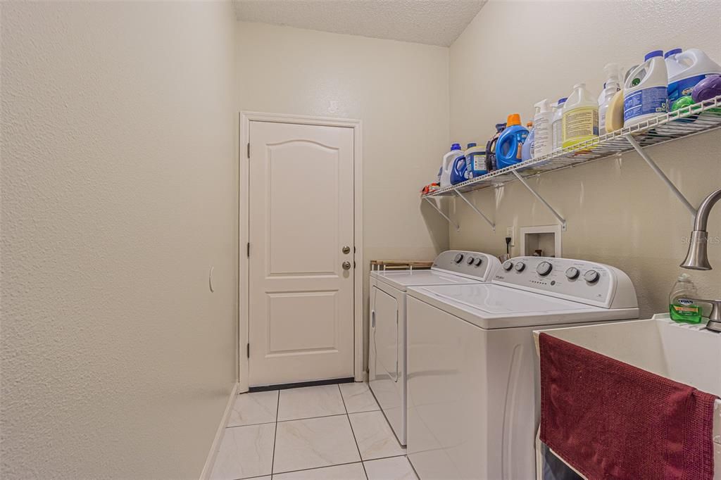 spacious laundry room with utility sink. Door goes to garage