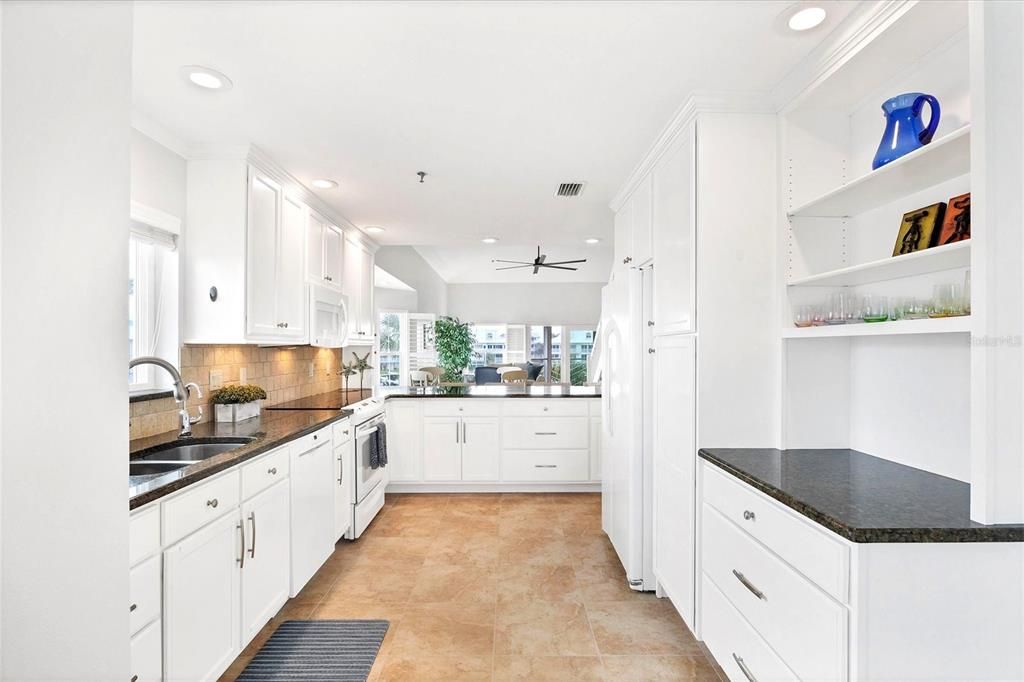 Kitchen is spacious & is highlighted with granite & a tiled backsplash