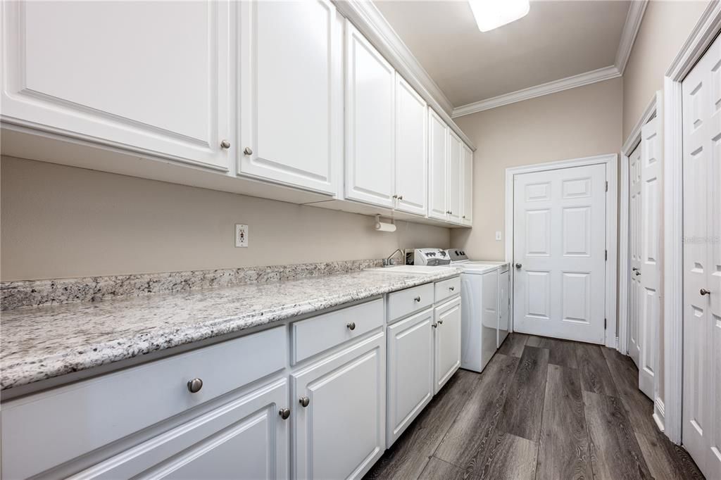 Laundry room with utility sink leading to garage.