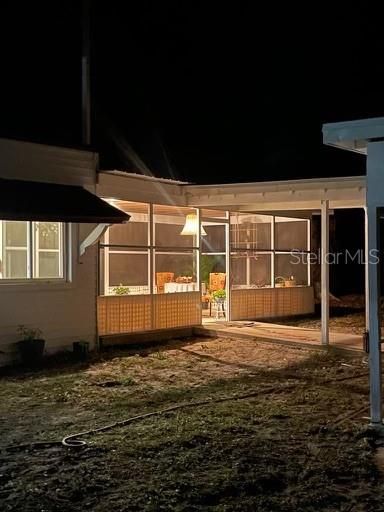 Evening view of back porch and covered walkway leading to carport