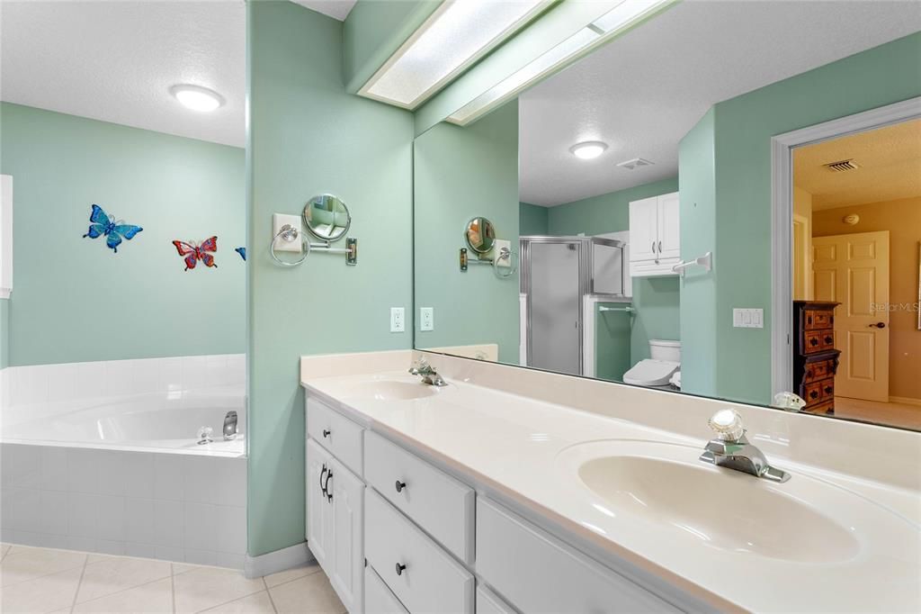 Primary Bath has solid counter, a separate shower stall with a bench, and a soaker tub