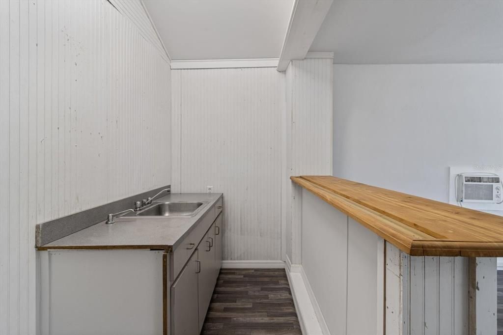 Kitchenette Area w/ Sink, Cabinetry & Breakfast Bar