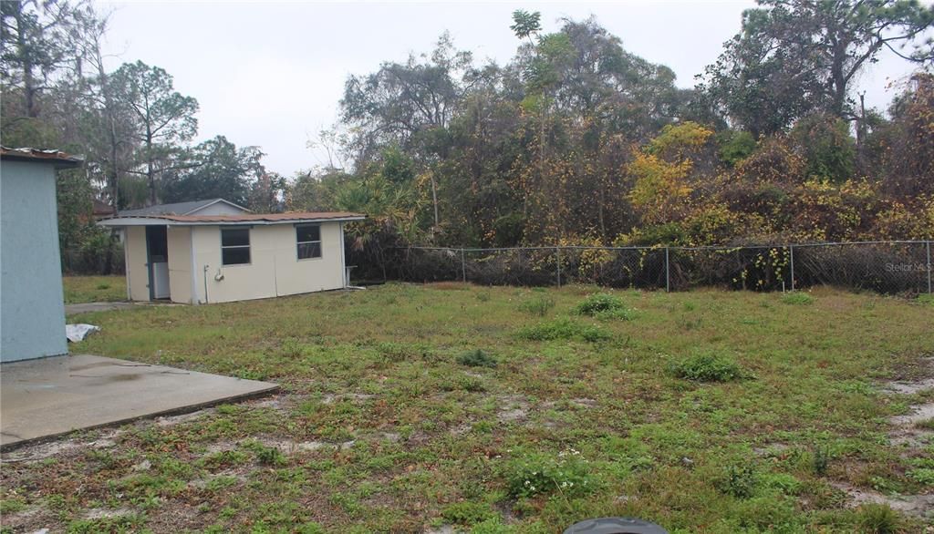 shed in back, backs to wooded area.