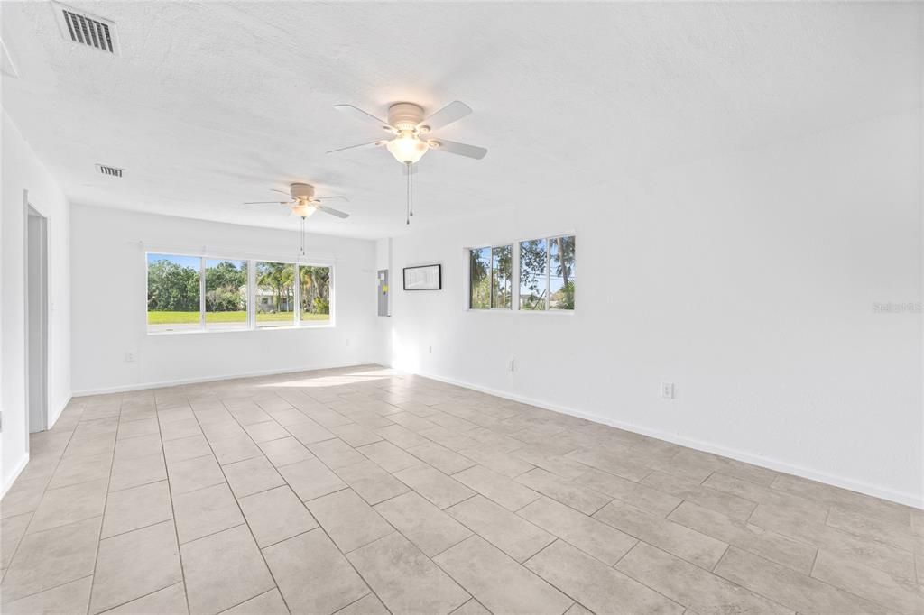 Large family room featuring tile flooring and two ceiling fans