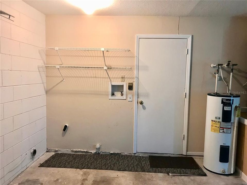 Laundry area in garage.  Door leads to breakfast area and kitchen.