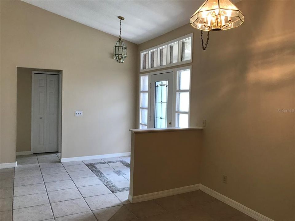 Dining alcove and entry; secondary bedrooms and hall through doorway at left.