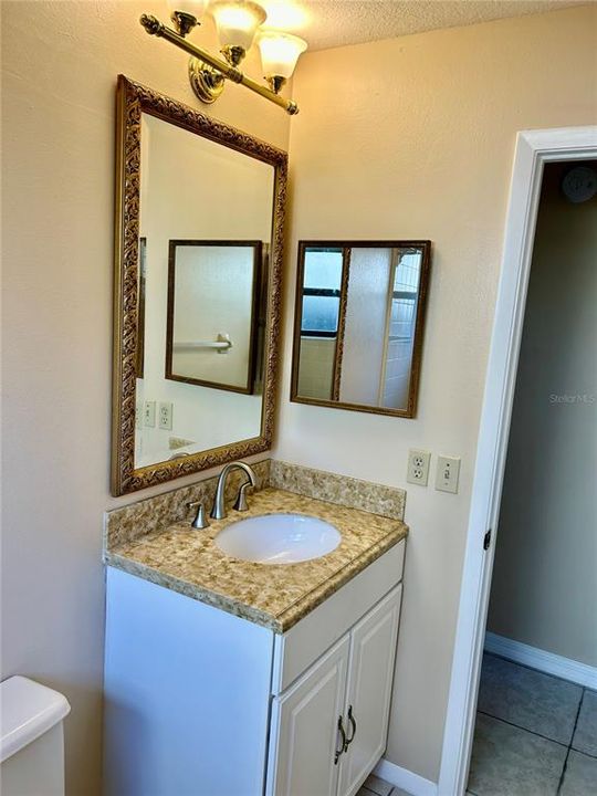 Secondary bath with granite countertop and undermount sink.