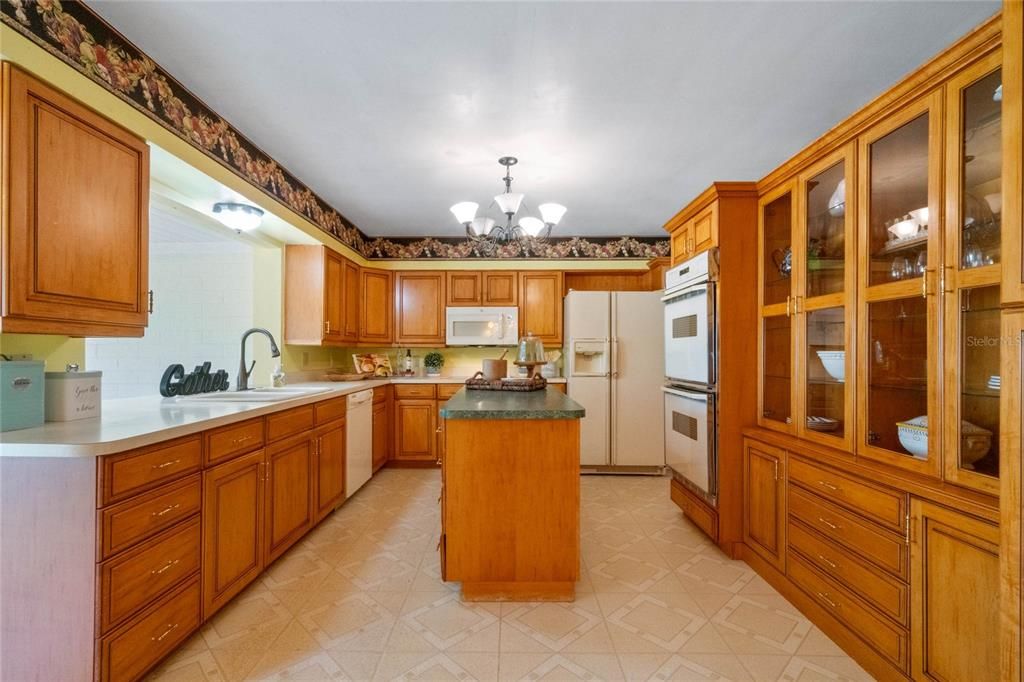 Kitchen has Beautiful Updated Cabinets With Roll-Out drawers, and Large Kitchen Island. Double Ovens. Kitchen Overlooks the Fully Glassed-In Sunroom and Backyard.