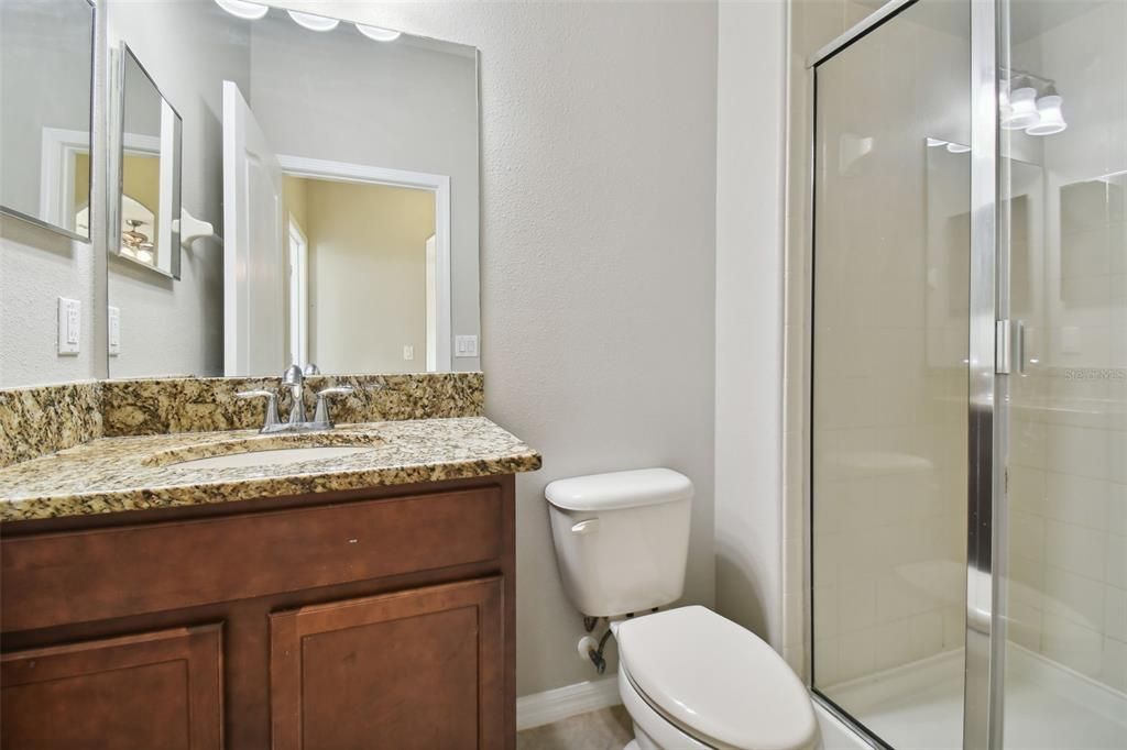 Bathroom on the first floor with granite sink and walk-in shower.