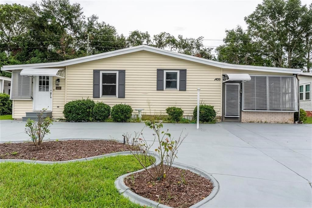 front with large driveway and parking