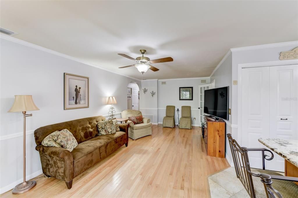 Family room with wood floors and crown molding is the perfect place to unwind and watch tv