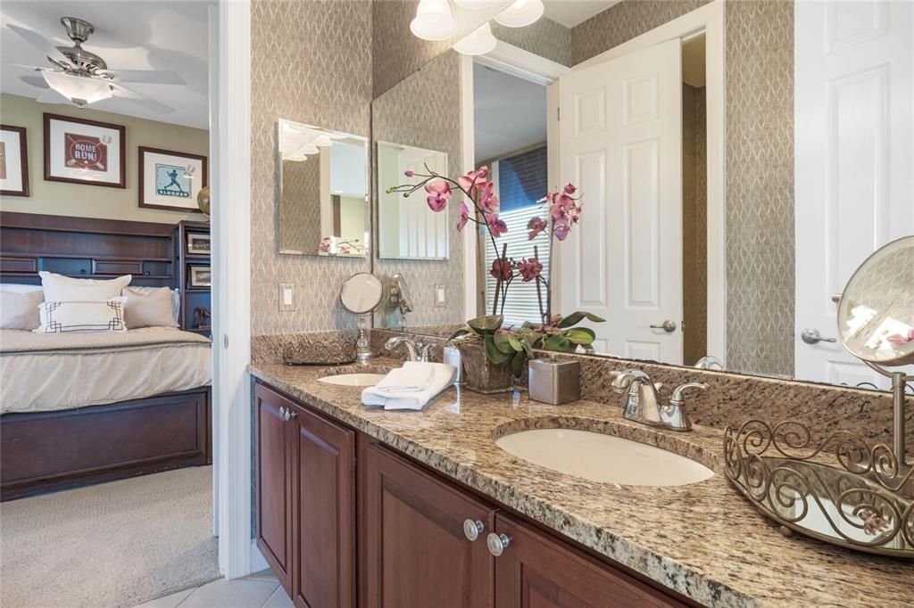 Jack & Jill bath with view of bedroom 2. This bath features dual sink granite topped vanity, shower & tub combo within toilet room for privacy. Shared between bedroom 2 & 3