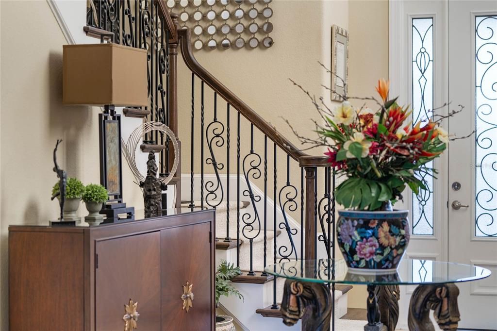 Foyer stairwell. Note the upgraded box wood treads with berber runner and elegant wrought iron railing.