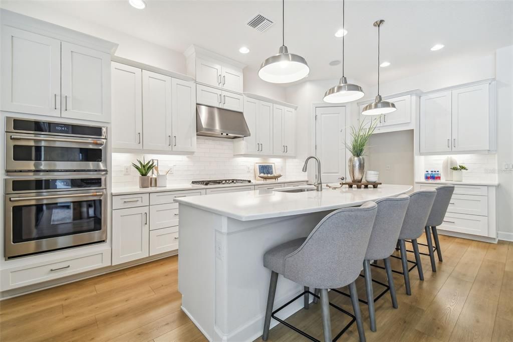 Wow! This kitchen has it all.....convection microwave, wall oven, gas burner cooktop, stainless steel hood, stone counters, upgraded wood cabinetry and a large massive island.