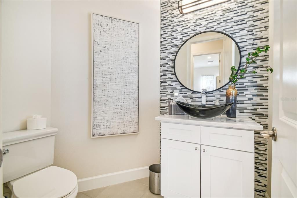 There is a half bath on the first floor. Notice the tiled focal wall and bowl sink.