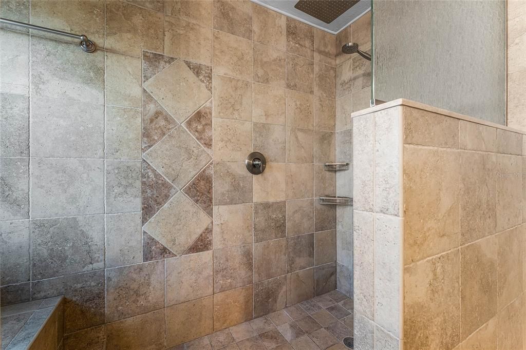 The walk in shower offers a bench and rainfall shower head.