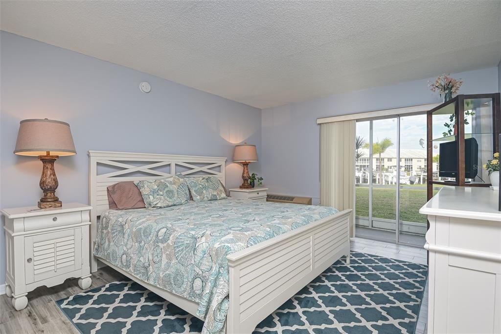 Large master bedroom with king size bed overlooking the waterfront. Sliders to the lanai/porch.