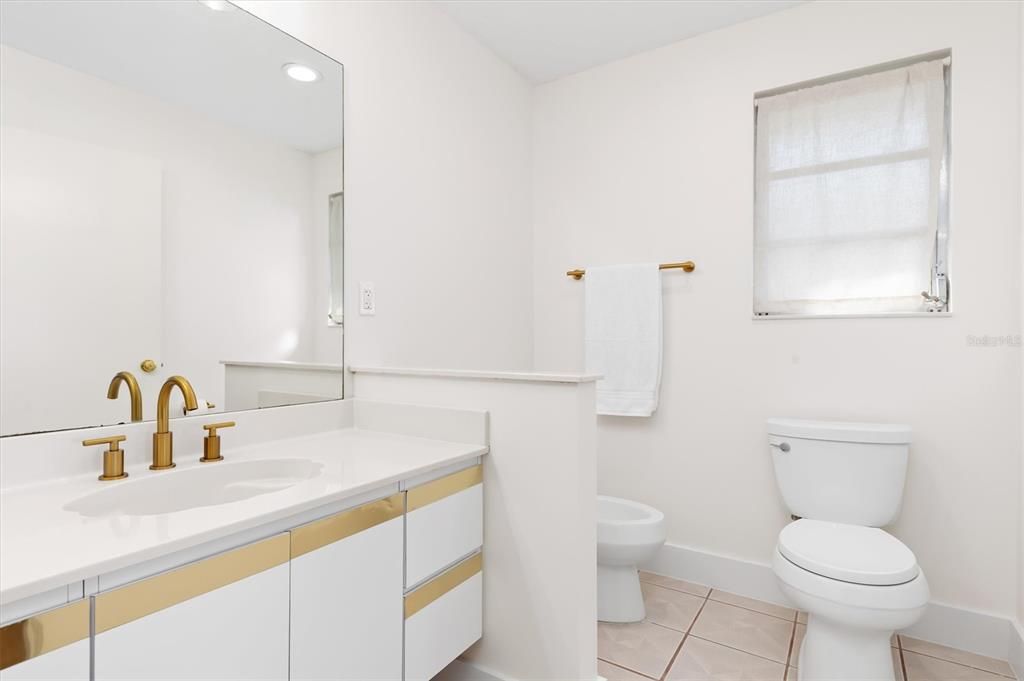 Long vanity, toilet and urinal in primary ensuite bath