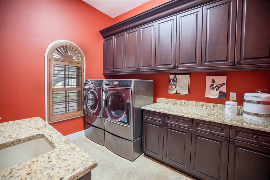 Laundry room with cabinets, granite counters and sink.