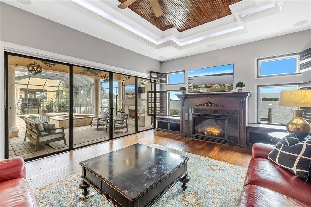 Family room with fireplace, hardwood floors and sliding door that lead to the pool/hot tub and lake.
