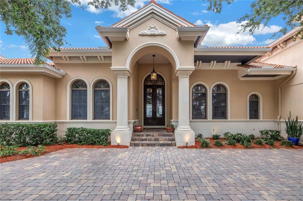 Exquisite Mediterranean Style Home on Lake Tarpon. French front doors, transum windows and tile roof.