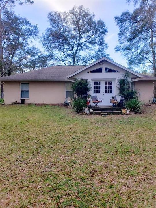 oversized back yard with mature trees fully fenced in with chain link fence