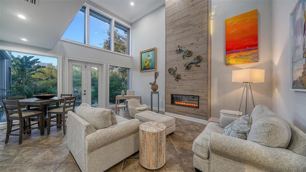 Formal living room with volume ceilings, French doors and wall of windows.  Custom built in electric fireplace with color changing remote feautre