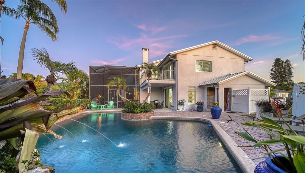 View of pool area and back of house.   Water feature is from the dolphins