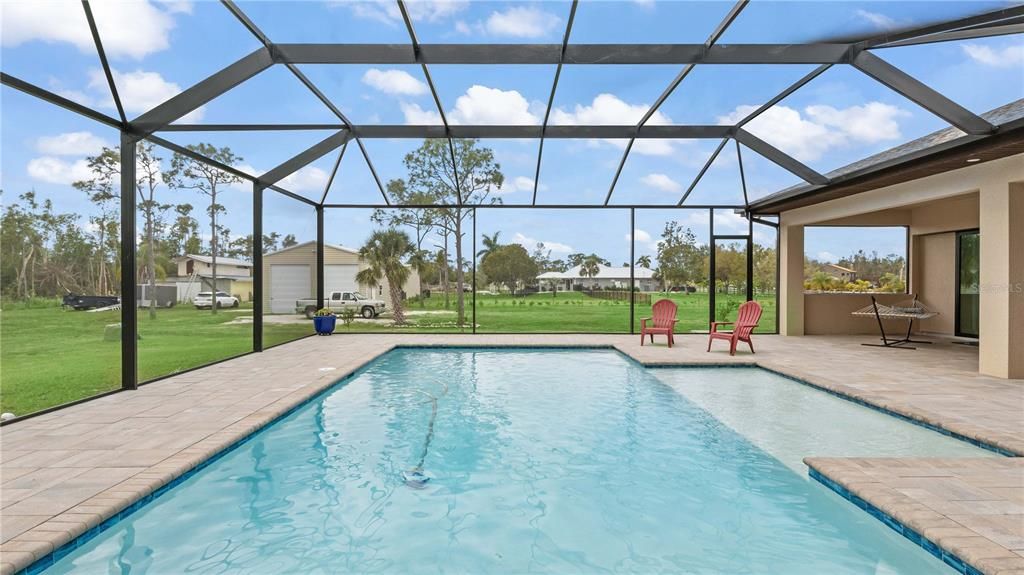 Pool - Sparkling **SALTWATER** heated pool with large sunning ledge and TONS of covered outdoor space! Reinforced and upgraded pool cage, super packed pavers and a pure outdoor oasis! South facing to get the best sun and also the perfect set up to kick back and watch the sunset from the west!