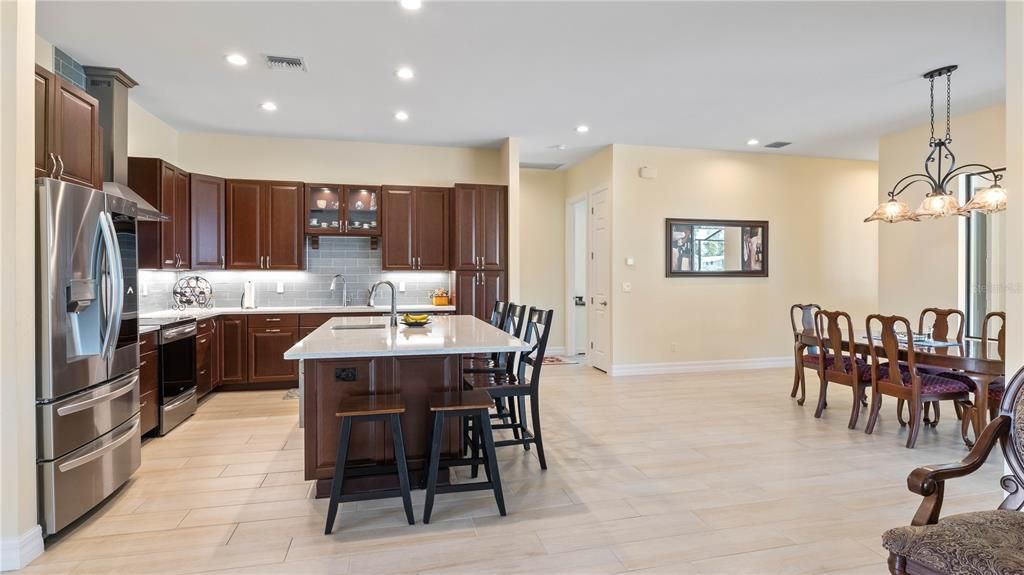 Kitchen - Calling all chefs! Kitchen is centered around the large island with plenty of room for everyone to gather! Open to the dining and the living area and beautiful views out to the pool!