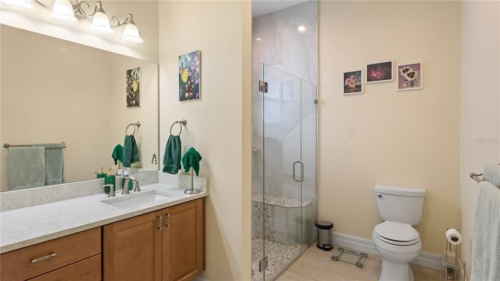In-law - Guest Home bathroom designed to be ADA compliant - large doors, raised vanity and there is a large sit down bench in the shower.