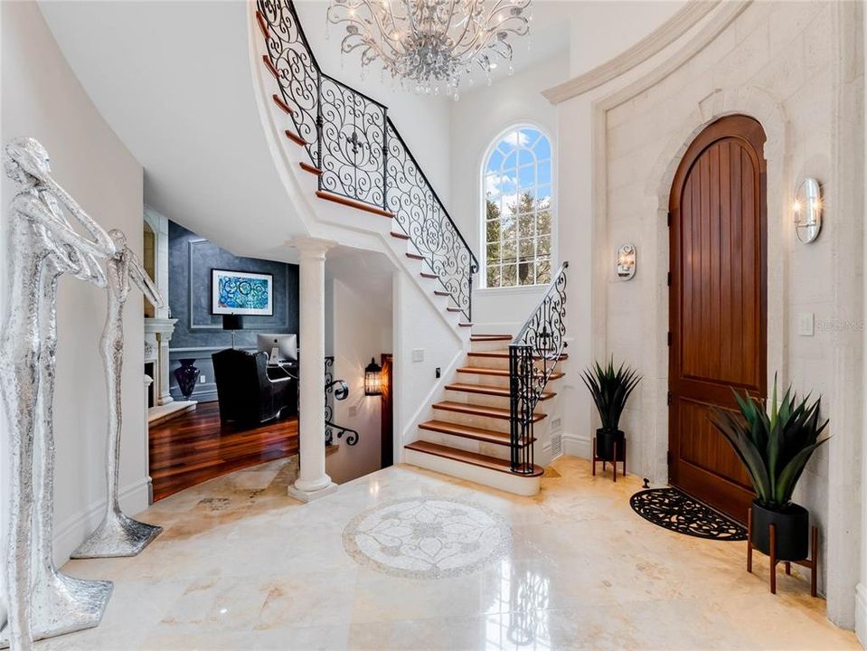 Foyer leading to spiral staircase, living room/office and steps to wine cellar.