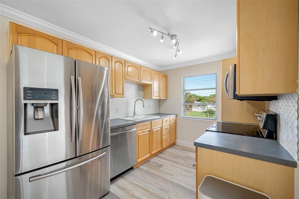 Solid wood cabinets, newer appliances, stylish new backsplash and faucet; window adds great natural light