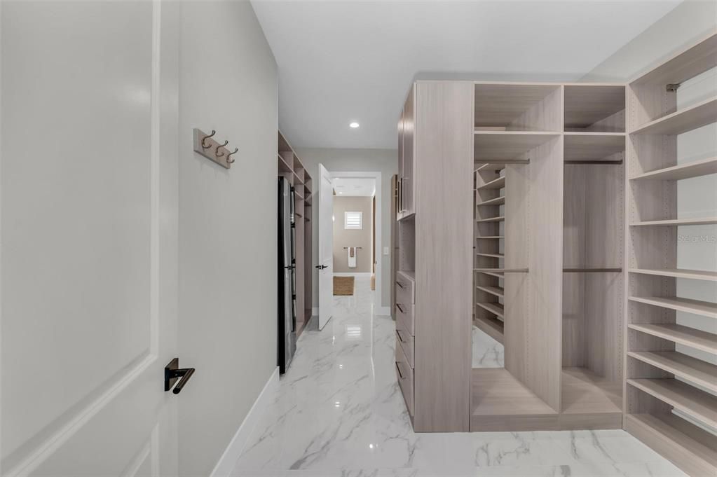 Impeccable primary closet that features a 24" Samsung AirDresser steam closet.