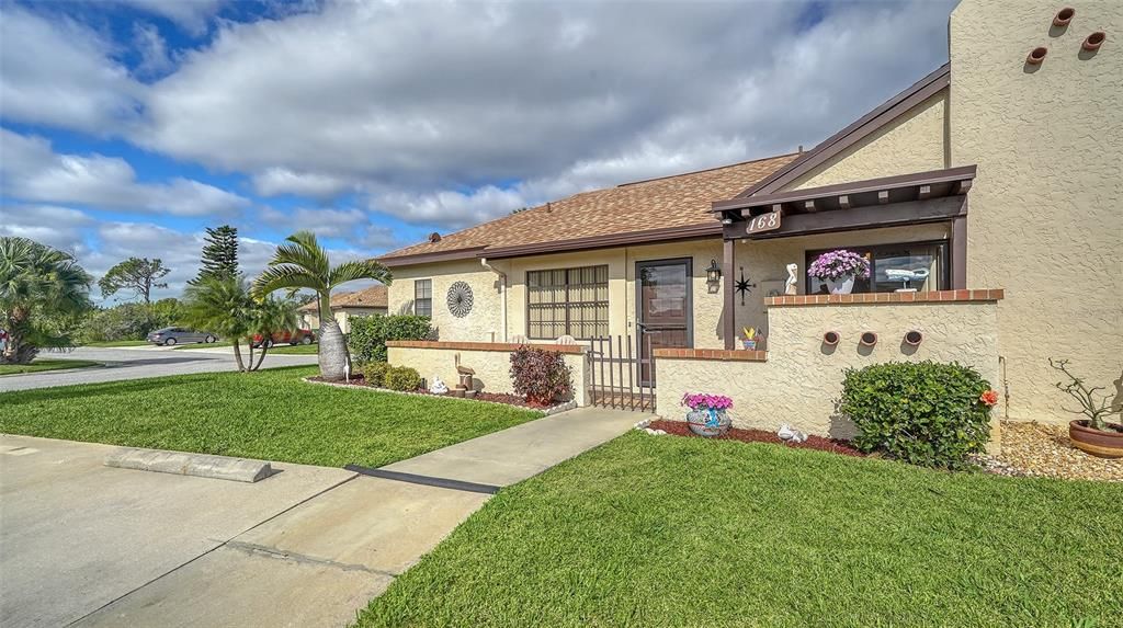 The villa offers two parking pads and a sidewalk to the main entrance.