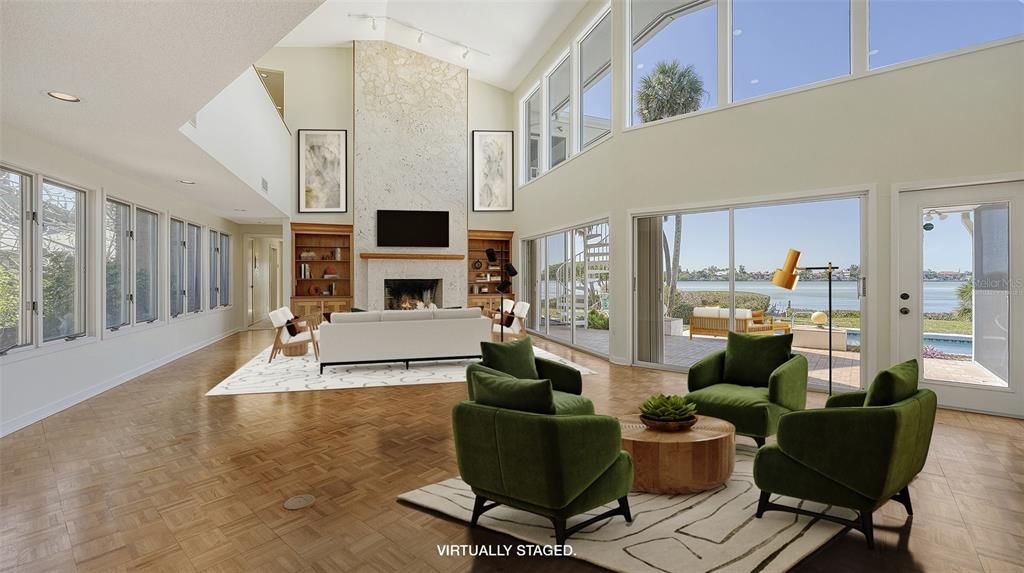 Light-filled living room with 19' ceiling and wide open views of the water.  Virtually staged.