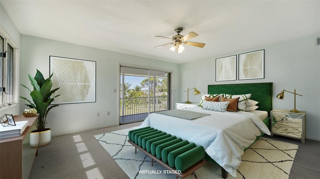 Primary bedroom with sliders to a screened balcony overlooking the pool and intracoastal waterway. Virtually staged.