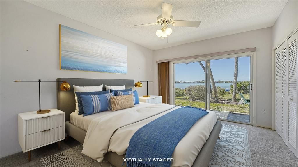 Bedroom 3 is on the main floor with sliders to the screened patio and water view beyond.  Virtually staged.