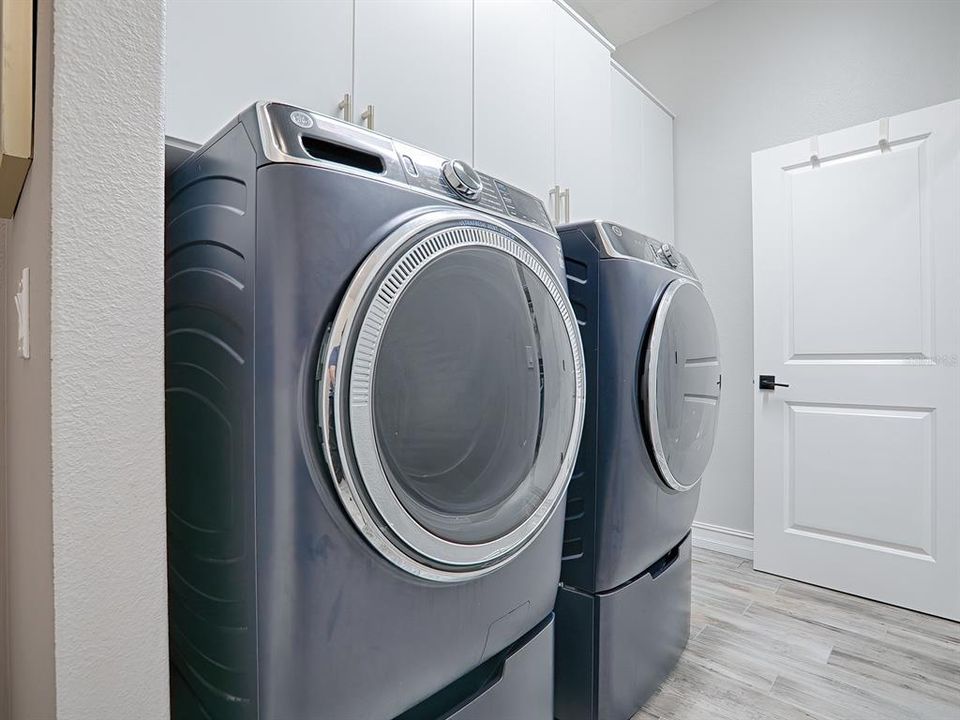 LAUNDRY ROOM IN THE HALLWAY LEADING TO THE GARAGE.  FRONT LOAD WASHER AND DRYER DO CONVEY WITH THE HOME.
