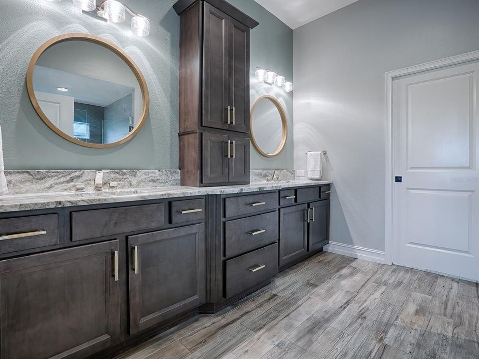 LOVELY PRIMARY BATH WITH GRANITE COUNTERS, CUSTOM MIRRORS AND FIXTURES. THE DOOR LEADS TO THE HUGE WALK-IN CLOSET WITH BUILT-INS.