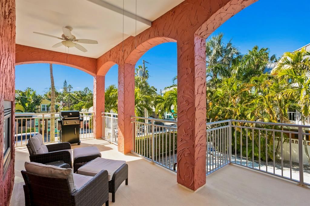 Weber gas grill on living room balcony overlooking heated pool