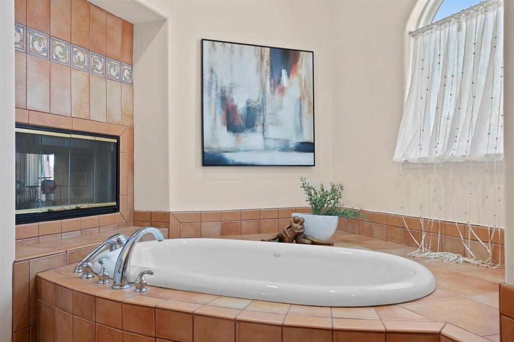 Primary soaking tub with wood burning fireplace